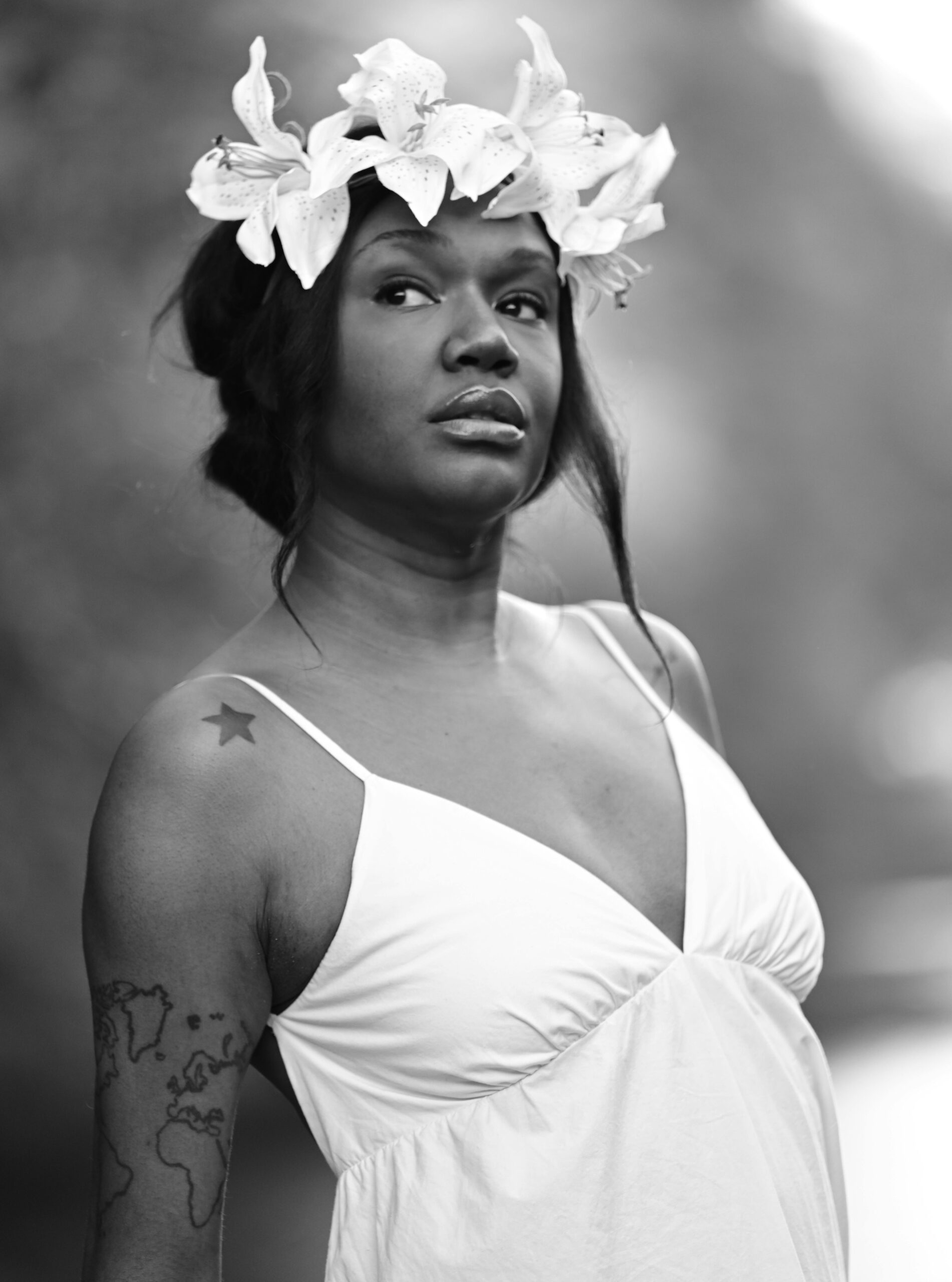 Black and white portrait of a woman with a floral headpiece, exuding grace.